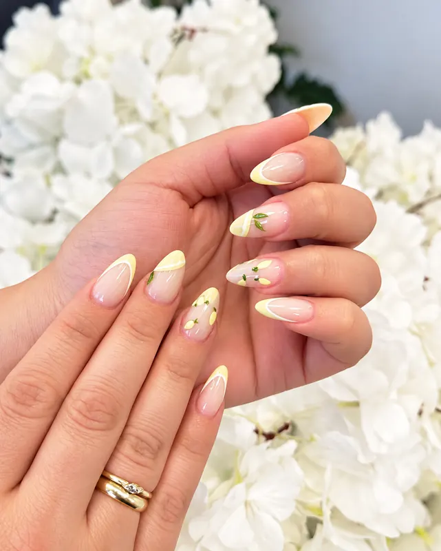 Nude Nägel mit gelben French Tips und kleinen Zitronen